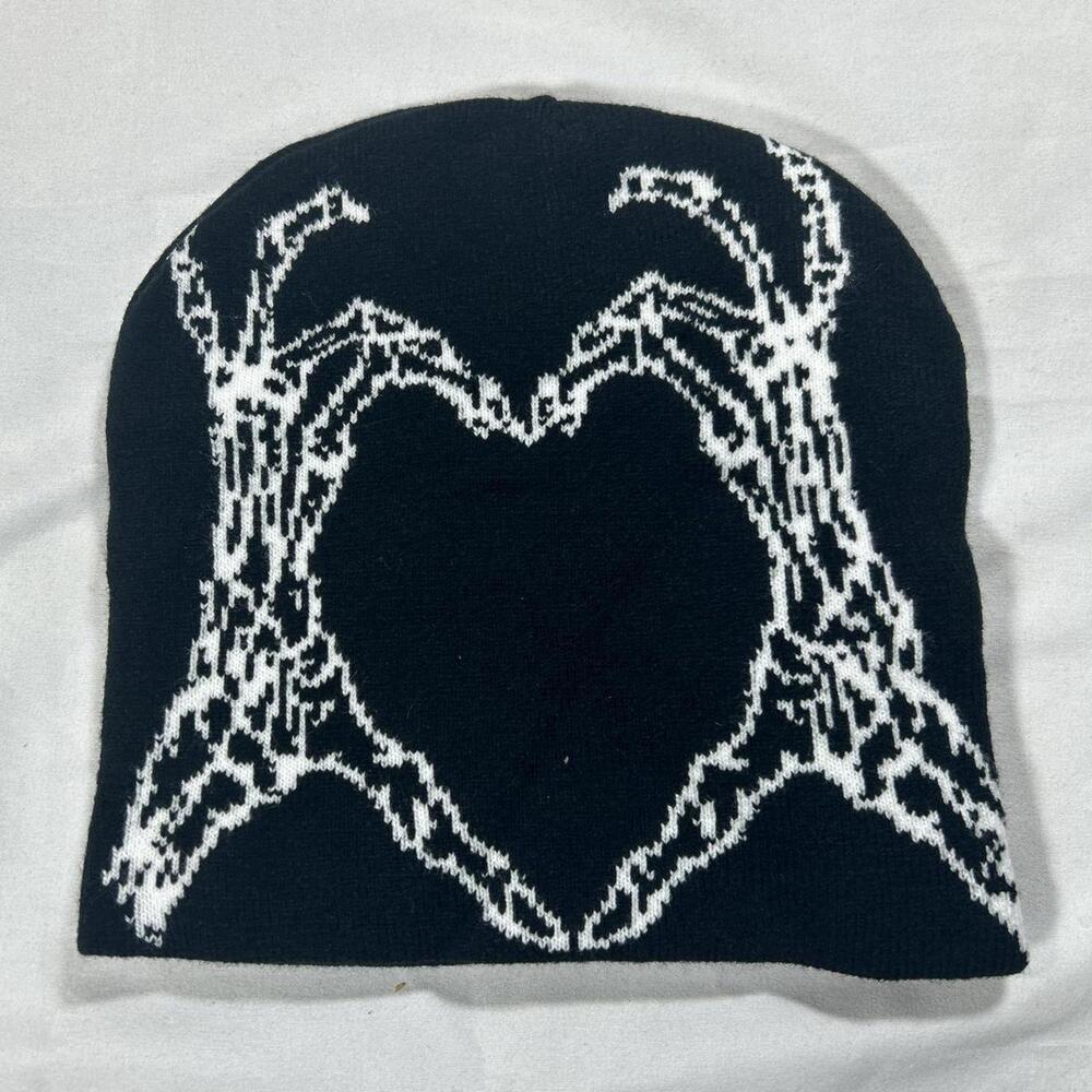 Black & white beanie with graphic of skeleton hands making a heart.